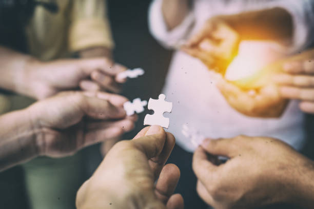 istock In selective focus of human hand assembling jigsaw puzzle,searching for right match,teamwork support to find common solution concept,blurry light around 1019477444