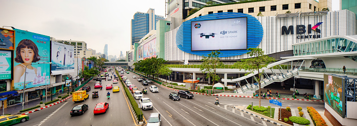 Bangkok Thailand Phayathai Road elevated panoramic view with MBK Center shopping mall to the right and several large advertising billboards to the left.
