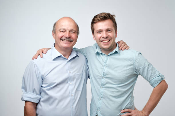 istock Hispanic father and adult son hugging and smiling at camera. 1019485592