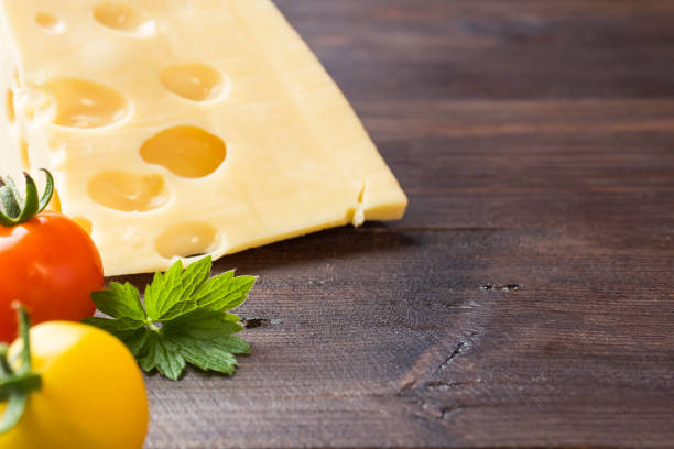 istock Cheese and tomatoes on dark wooden background with copy space 1019493988