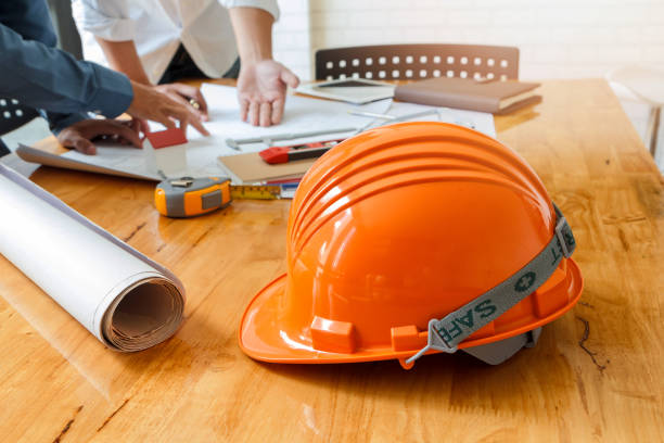 istock helmet on wooden desk with architect background 1019499698