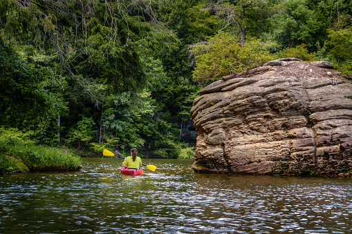 Photo of a young woman kayaking on the river with her dog