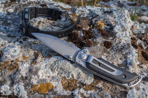 istock Folding knife and men's watch on stone 1019517760