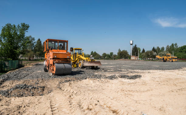 istock Orange light Vibration roller compactor standing on a stones at road construction and repairing asphalt pavement works with a blue sky. 1019518106