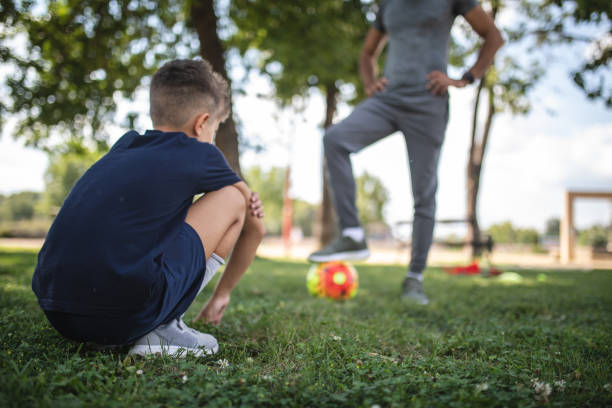 istock Child and father playing soccer at a park 1019539104