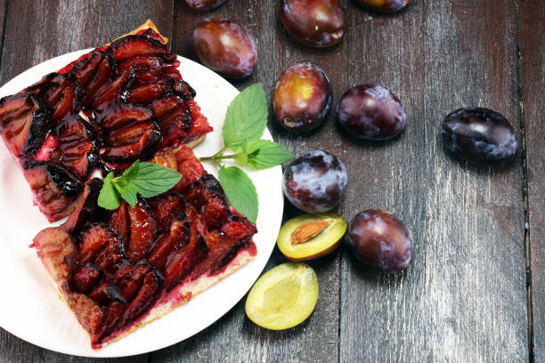 istock Rustic plum cake on wooden background with plums around. 1019539238