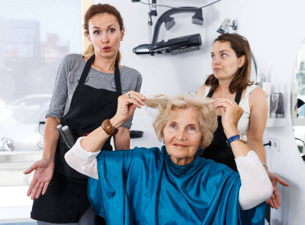 Shocked elderly female client at barbershop Portrait of shocked elderly female client with apologetic hairdressers at barbershop angry hairstylist stock pictures, royalty-free photos & images