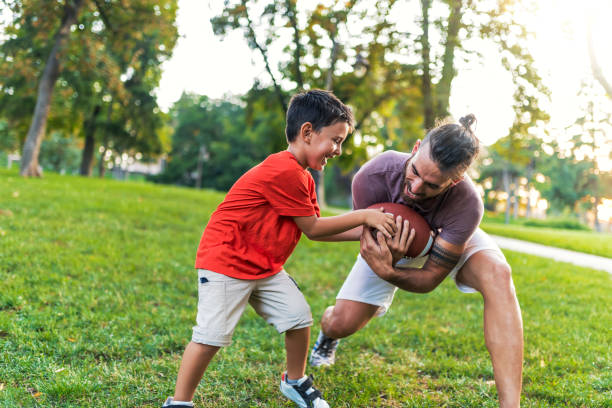 istock Happy boy playing rugby with father at park 1019548338