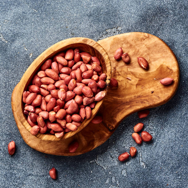 istock Peeled peanuts in bowl on gray background. Top view of nuts. 1019554402
