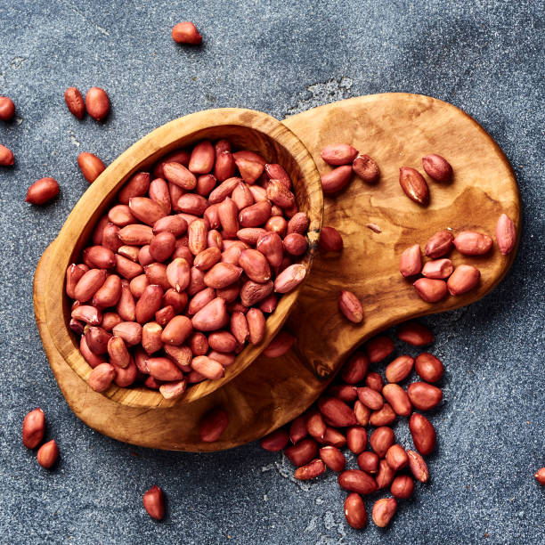 istock Peeled peanuts in bowl on gray background. Top view of nuts. 1019554438