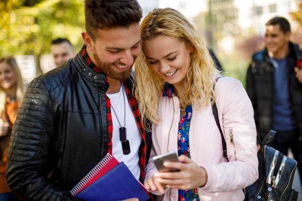 istock College students using mobile phone outdoors 1019562474