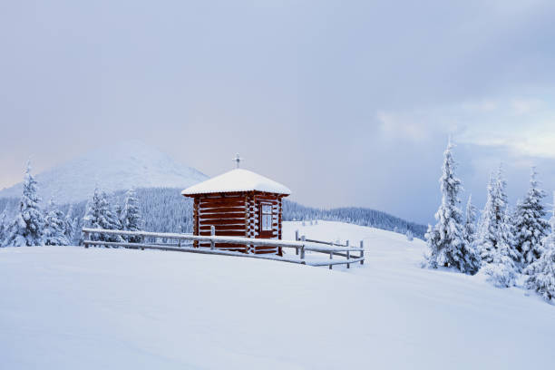 no gramado há igreja de madeira coberto com neve alta nas montanhas e em torno dela há uma floresta com belas árvores. - rural scene winter outdoors horizontal - fotografias e filmes do acervo