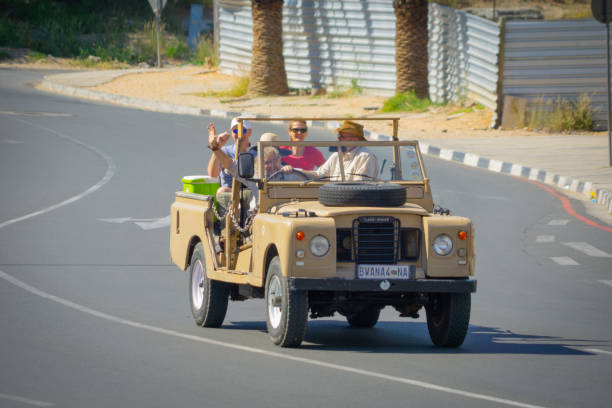 Group tourists being driven through city in open 4wd with guide in Windhoek, Namibia in May 2018
