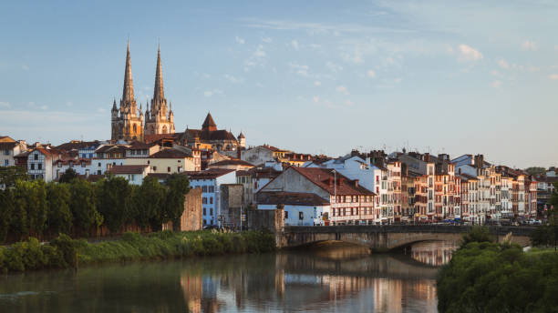 Bayonne, France cityscape view with Cathedral and Nive river Cityscape view of Bayonne, France, in the south western basque country region, looking along the river Nive witha bridge in the foreground and the old townhouses and spires of the cathedral behind it. sainte marie stock pictures, royalty-free photos & images