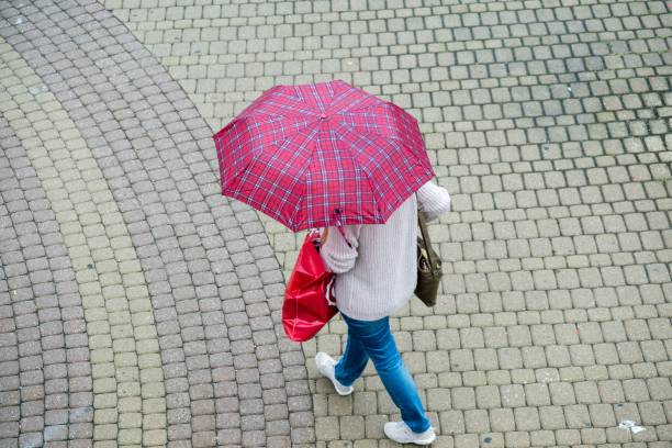 istock Rain in the town, people with umbrellas. 1019581322