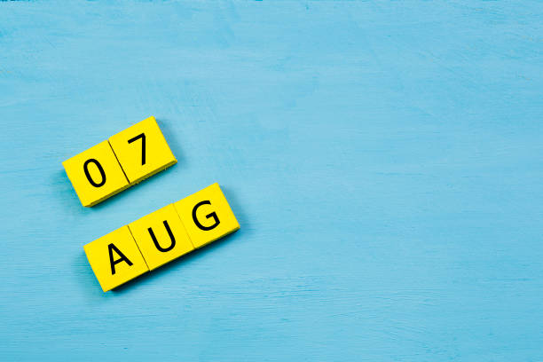 aug 1, calendrier de cube jaune sur une surface en bois bleue avec espace copie - 7 week old photos et images de collection