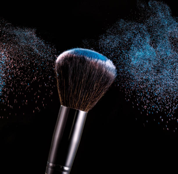 istock Make up brush with powder splashes on black background 1019588640
