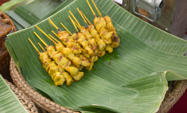 Appetizing Chicken Satay resting on banana leaves after being grilled, ready to be served at a street market.