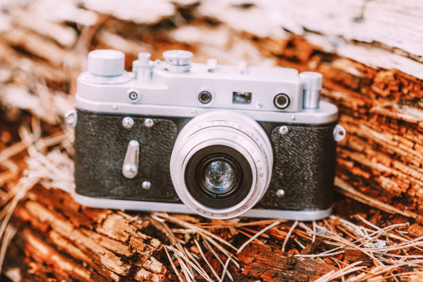 istock 35mm Vintage Old Retro Small-Format Camera On Old Fallen Wood Tree In Forest 1019603484