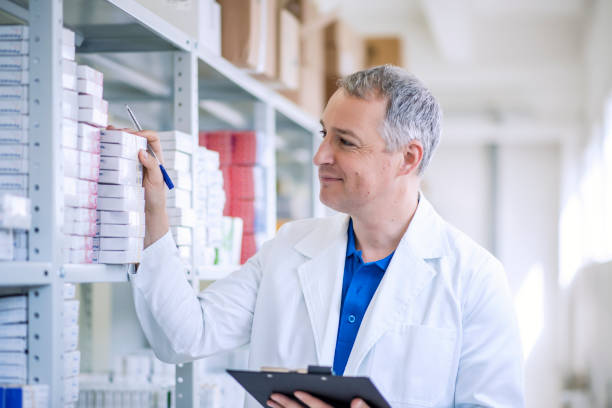 Portrait of mature male pharmacists working in modern drugstore Portrait of mature male pharmacists working in modern drugstore. Perfect medication. Shot of a mature pharmacist looking for an ordered drug on a shelf at the local pharmacy. medical supplies stock pictures, royalty-free photos & images