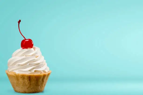 Cupcake with whipped cream and cherry