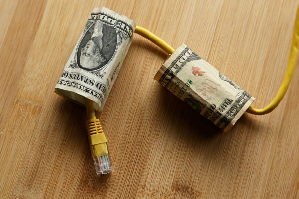 The cost of internet data plans in America concept image consisting of USA dollar bills and an Ethernet cable. The cost of internet data plans in America concept image consisting of USA dollar bills and an Ethernet cable. This image can also be used to represent net neutrality or online income. broadband isp stock pictures, royalty-free photos & images