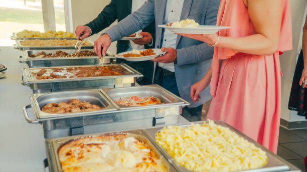 istock buffet: people take food in plates. 1019611134