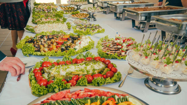 istock buffet: people take food in plates. 1019611182