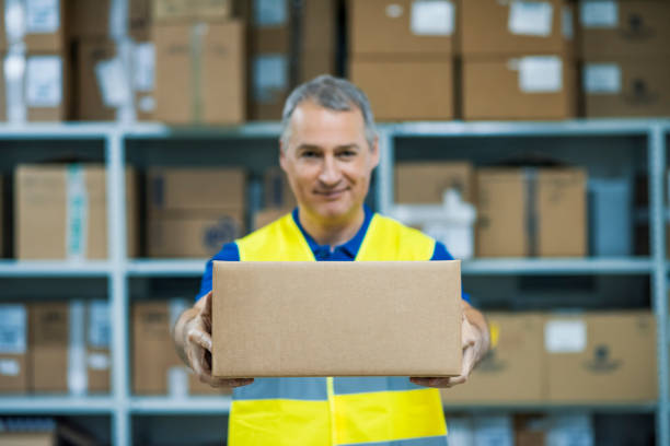 Smiling warehouse workers preparing a shipment in a large warehouse