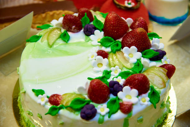 istock A bright cake decorated with strawberries and flowers close-up in the display case. 1019615036