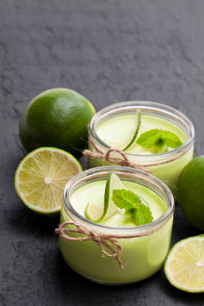 istock Natural  lime yogurt in a small glass jar on black stone background 1019616778