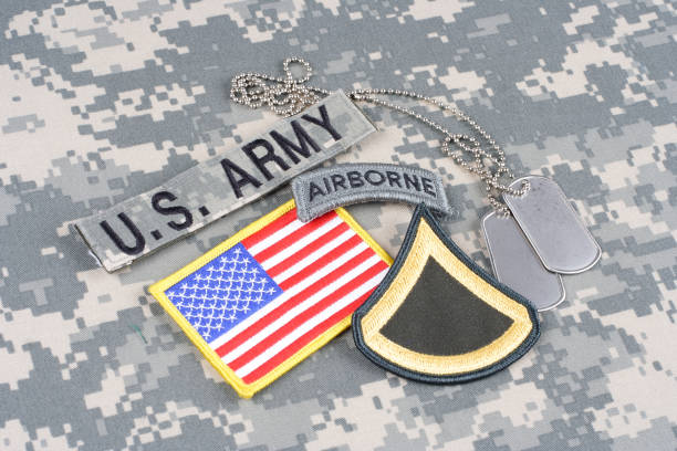 istock US ARMY Private First Class rank patch, airborne tab, flag patch, with dog tag on camouflage uniform 1019620564