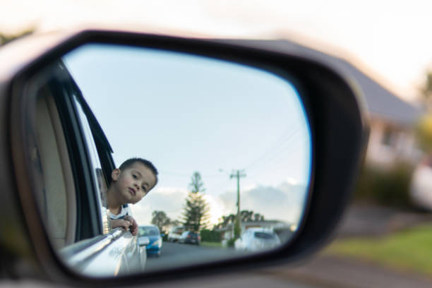 Side mirror with a little boy's face in the reflection stock photo