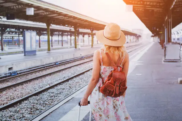 Photo of travel background, woman traveler with baggage, passenger waiting for the train on platform