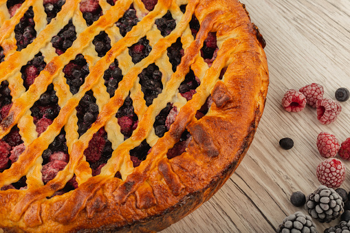 Berry pie on a wooden background with ingredients