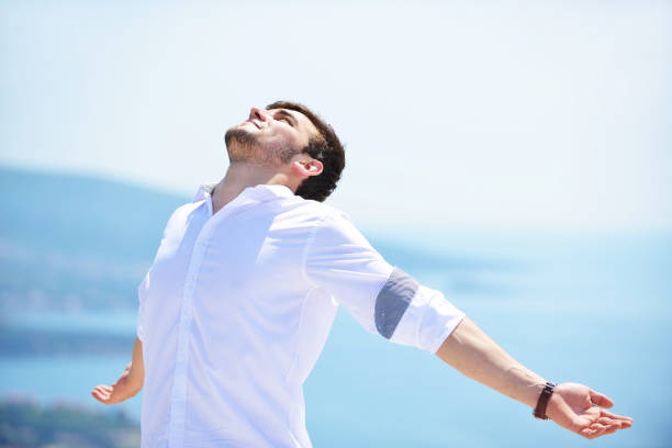 istock Handsome business man standing on a seaside and looking into the distance. 1019656368