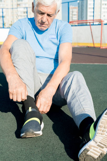 istock Senior Man Tying Shoes on Track 1019656732