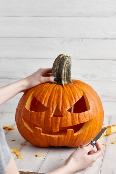 istock Carving halloween pumpkin into jack-o-lantern, close up view 1019670890
