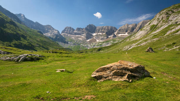 Green meadow in a sunny mountain valley in Pyrenees stock photo