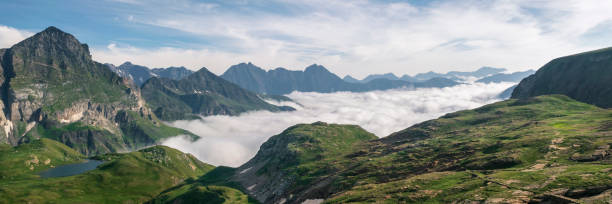 Panoramic view of a wide mountain range with cloud inversion stock photo