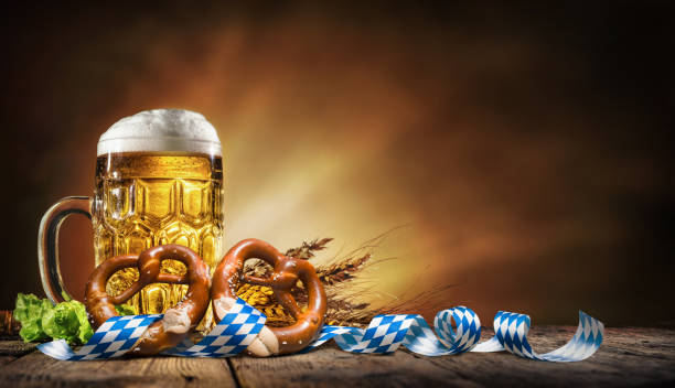 oktoberfest bier mit brezel, weizen und hopfen - bundesland bayern stock-fotos und bilder