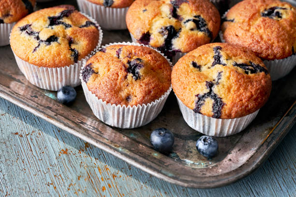 istock Tasty blueberry muffins on old baking tray sitting on rustic wood, text space 1019699070