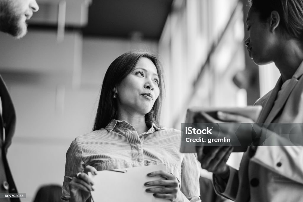 Gruppo di uomini d'affari che parlano in ufficio - Foto stock royalty-free di Bianco e nero