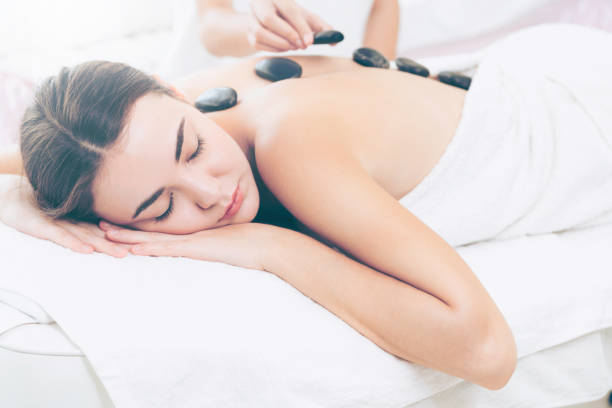istock Hot stone massage treatment by therapist in spa. 1019709590