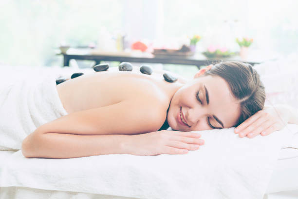 istock Hot stone massage treatment by therapist in spa. 1019709624