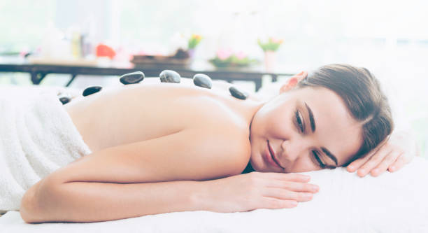istock Hot stone massage treatment by therapist in spa. 1019709654