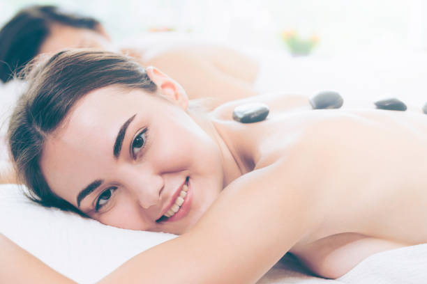 istock Hot stone massage treatment by therapist in spa. 1019709666