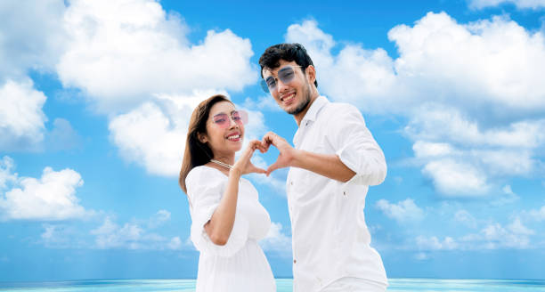 istock Happy couple making heart sign gesture with hands. 1019716252