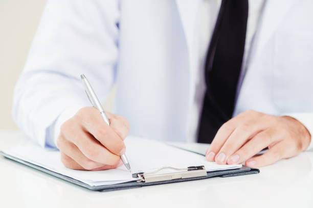 istock Doctor in hospital writing on a paper document. 1019724182
