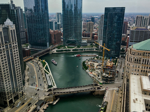 High angle view of Wolf Point on the Chicago River as a barge with debris heads north and tourist boat heads east.